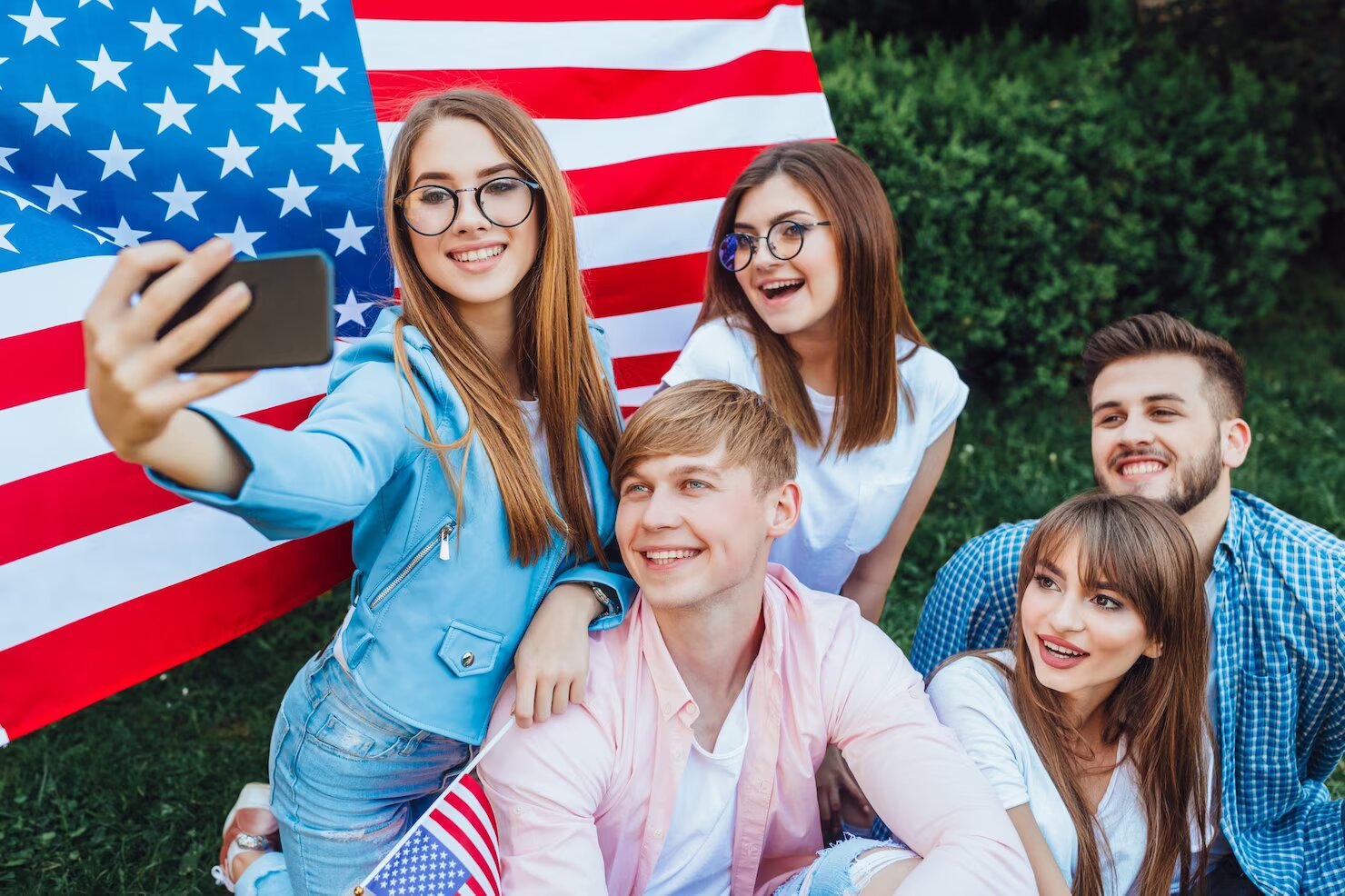 um-grupo-de-jovens-americanos-fazendo-selfie-com-a-bandeira-americana_496169-2326